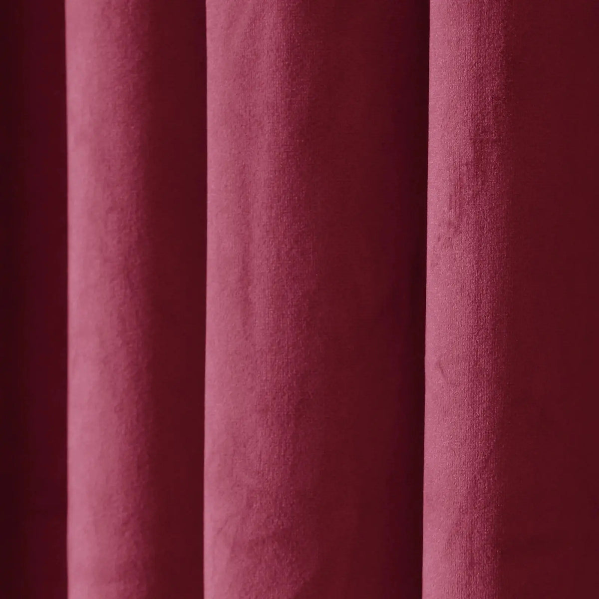 Photograph of rich maroon textured fabric with soft vertical drapes creating subtle shadows