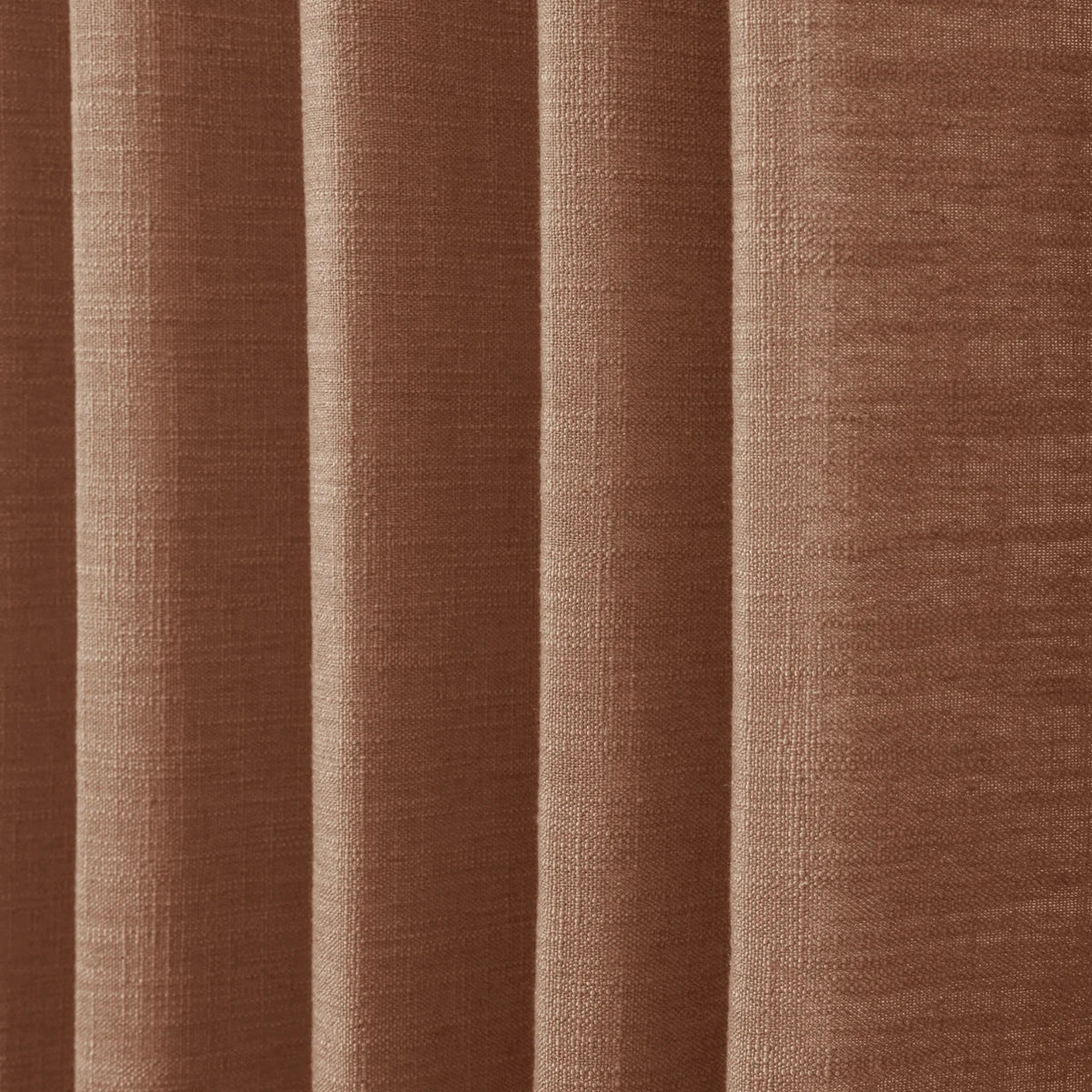 Orange Copper Liz linen curtains in a wider lifestyle scene with furnishings and softly flowing folds