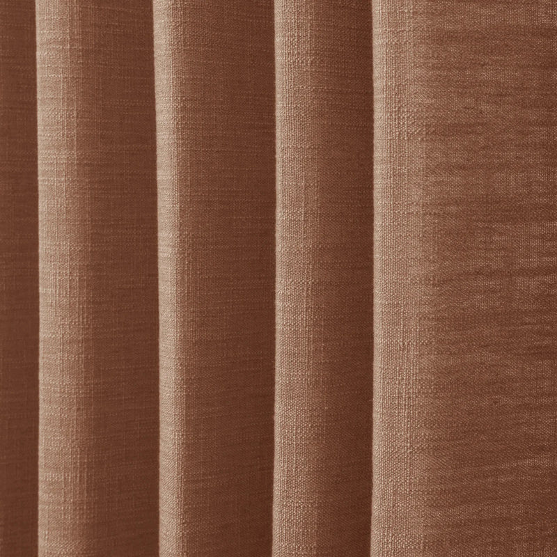 Orange Copper Liz linen curtains in a wider lifestyle scene with furnishings and softly flowing folds