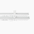 Product photograph of a modern white double curtain track system featuring a central ceiling mount bracket rows of D-shaped gliders and sleek end caps