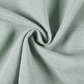Photograph of mint green coarse woven fabric gently swirled into a soft spiral